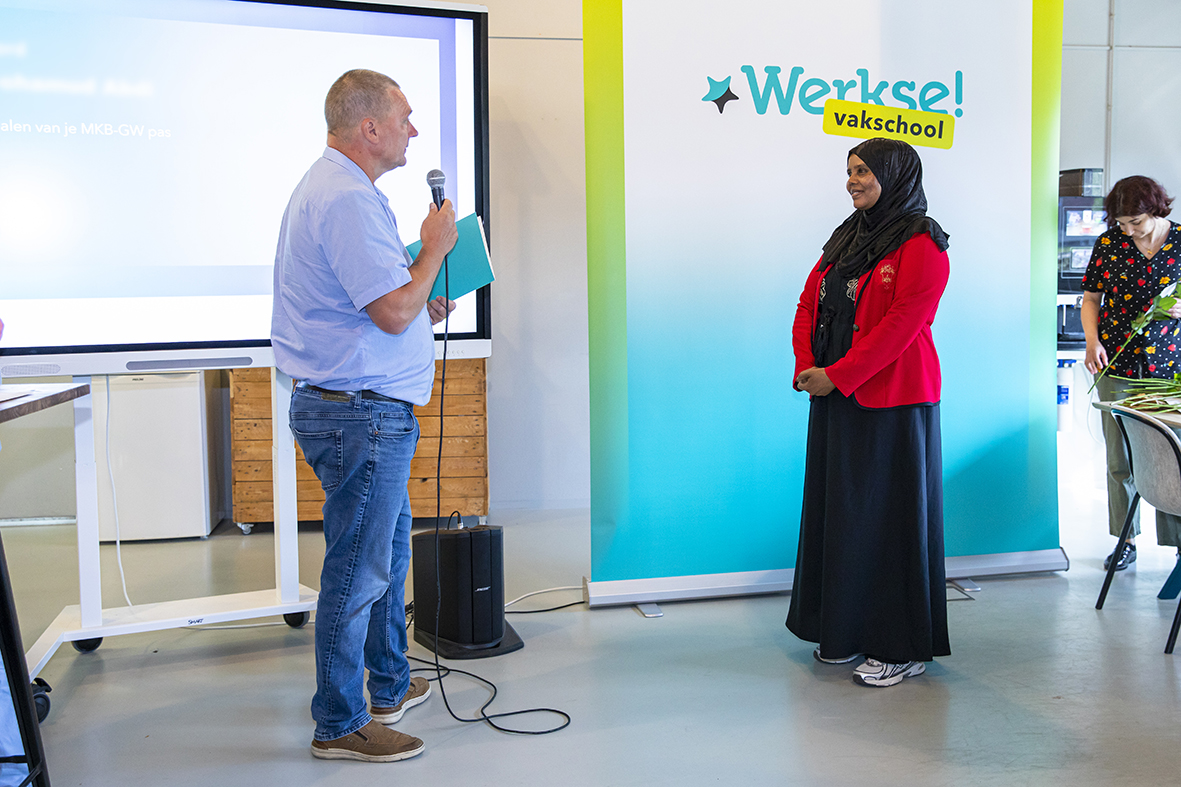 Vrouwelijk cursist wordt positief toegesproken door begeleider