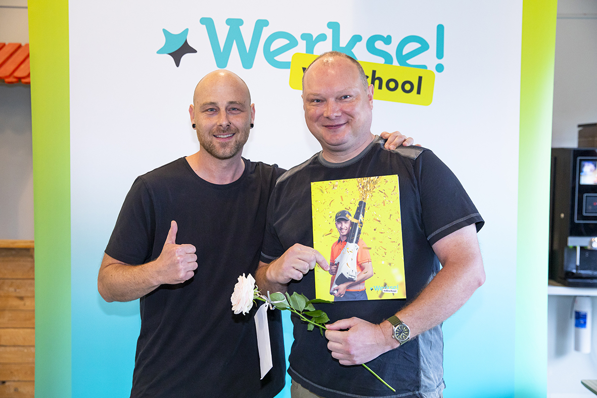 Cursist met begeleider samen op de foto. Begeleider heeft arm om cursist geslagen
