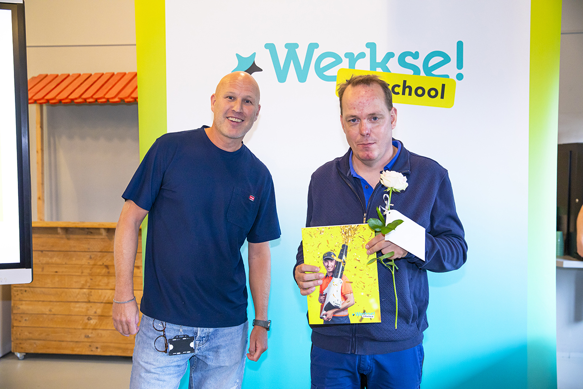 Cursist met certificaat en bloem en begeleider samen op de foto na de uitreiking