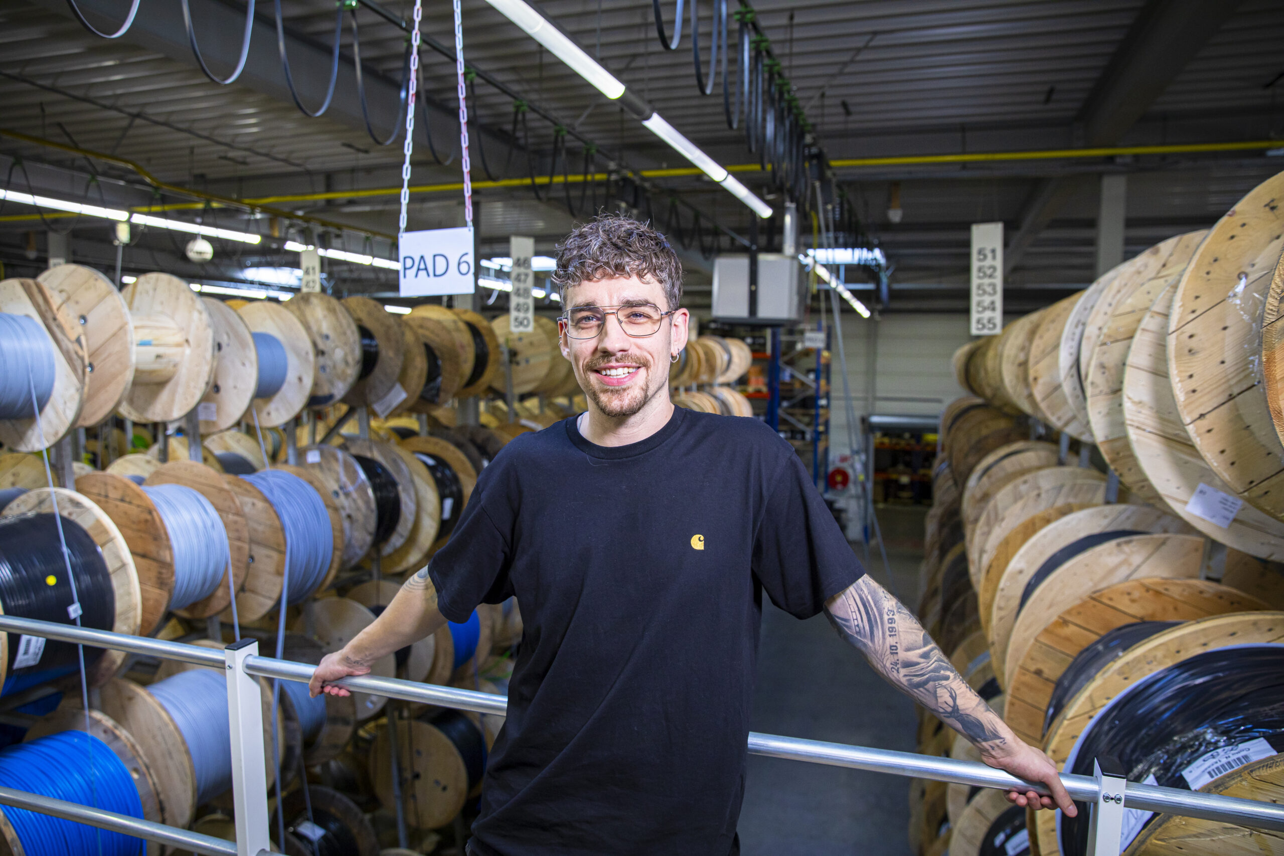 Daniel Henny poseert met op de achtergrond hangende kabelhaspels.
